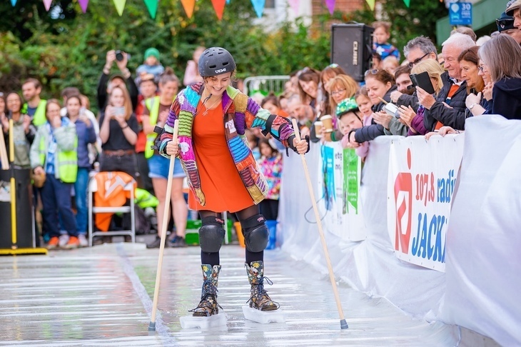 A woman reverse-skiing, with ice strapped to her boots