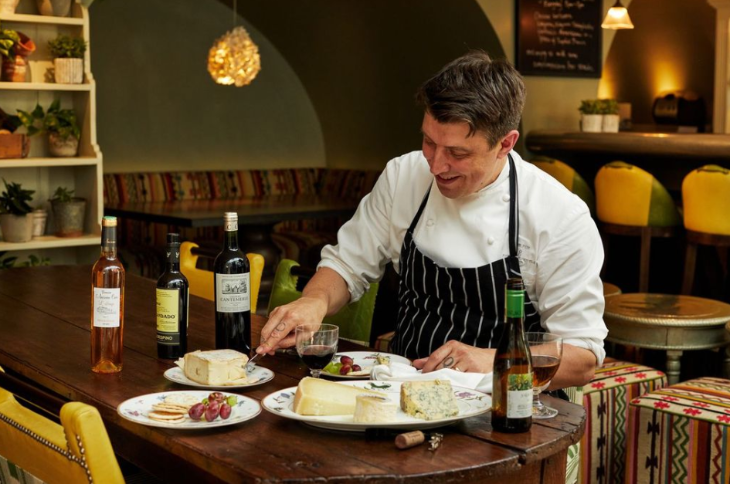 What's on today in London: a chef sitting at a table with wine and cheese