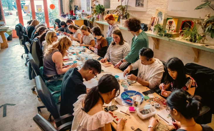 Things to do in London this weekend: people sitting around a long table taking part in a craft workshop