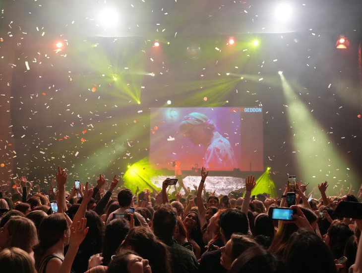 Things to do in London today:  people dancing as confetti falls and a Taylor Swift video plays on a large screen