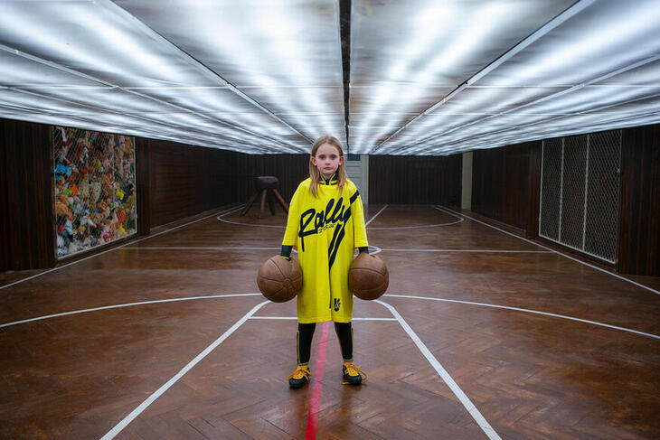 A young girl with two basketballs