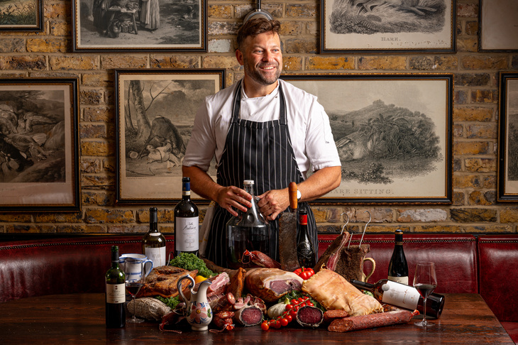 A chef with lots of meat and wine