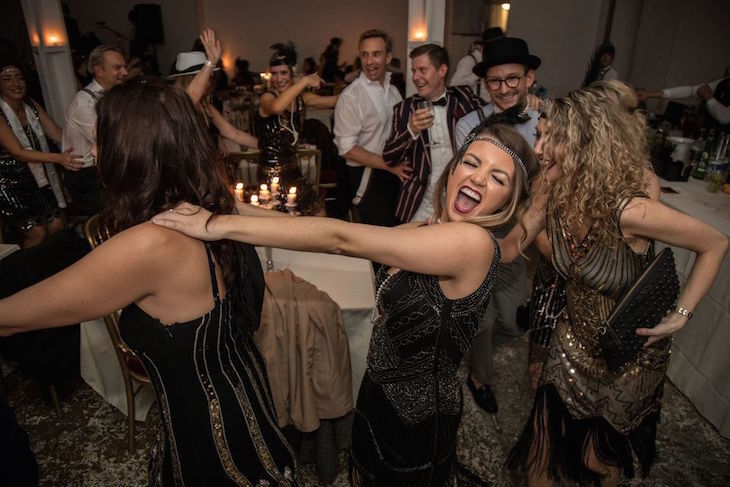 New Year's Eve parties London: people dressed in 1920s outfits dancing in a conga-style line