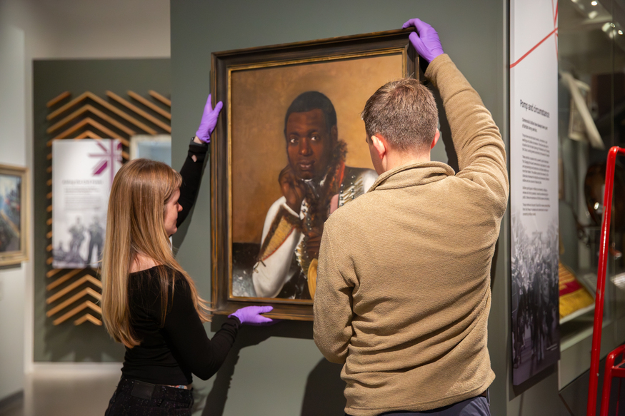 The portrait being hung