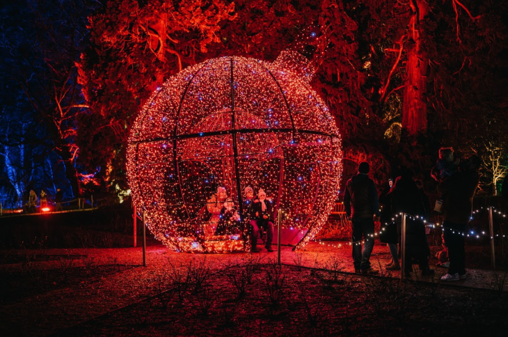 Christmas winter light festivals and trails London 2025: people inside a giant red illuminated bauble as part of a Christmas lights trail in Chelsea
