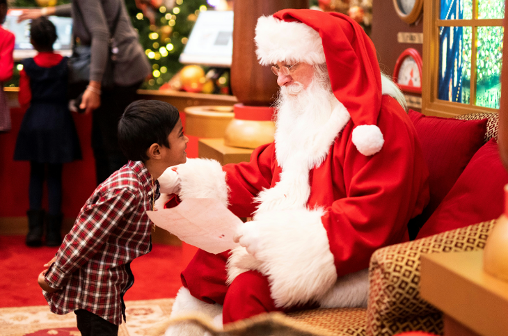 Best Santa's grottos meet Father Christmas London 2025 tickets: a young boy leaning forward to talk to Father Christmas