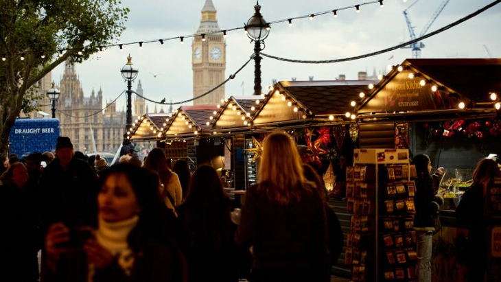 What's on in London in November 2025: a Christmas market with wooden chalets on South Bank, with Big Ben in the background