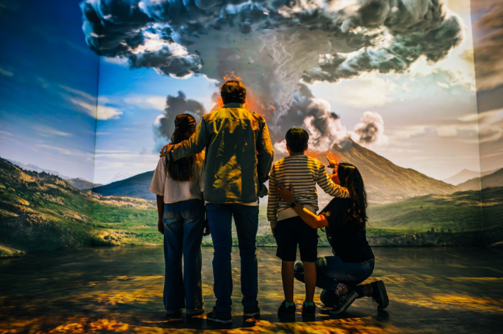 What's on in London in November 2025: a family standing in front of a screen depicting the eruption of Vesuvius