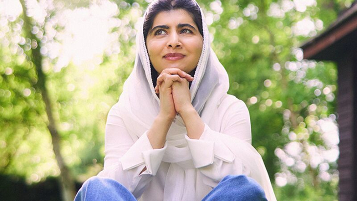 Things to do in London November 2025:  Malala wearing a white top sat in a wooded area