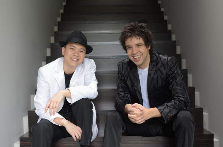 Today's events in London:  two men sitting on stairs, smiling at the camera