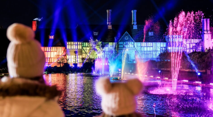 Winter light trails festivals near London Christmas 2025: a woman and child wearing woolly hats watching illuminated dancing fountains