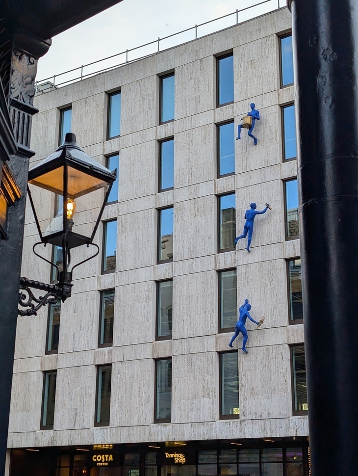 London pubs: blue men scaling a building