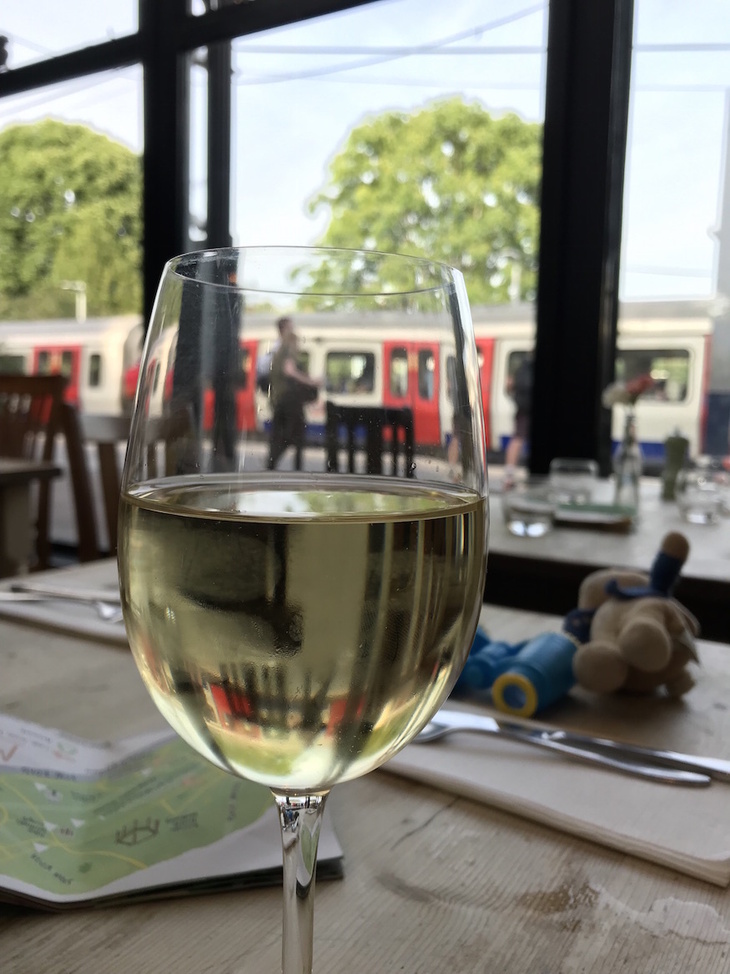 Best London pubs: a glass of wine in front of a Tube train