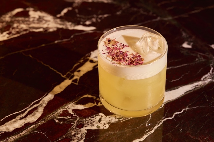 A cocktail topped with petals