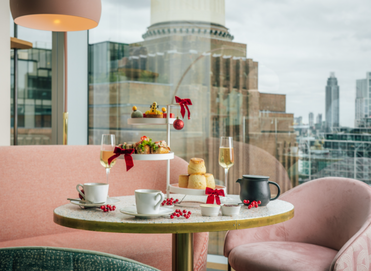 Best Christmas festive afternoon teas London 2025: a festive afternoon tea in front of a window overlooking a Battersea Power Station chimney