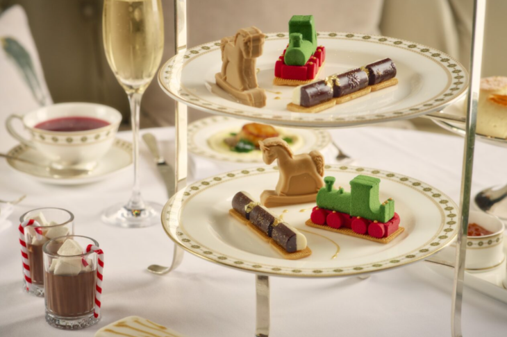 Best Christmas festive afternoon teas London 2025: pastries in the shape of a rocking horse and toy trains on tiered stands at the Hamleys afternoon tea