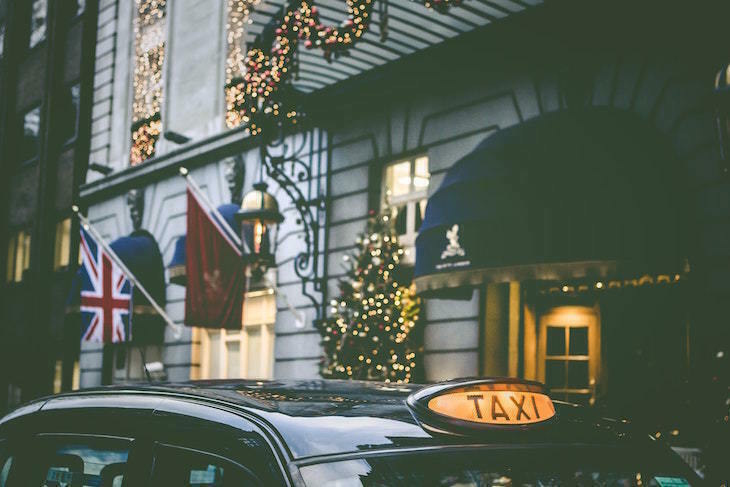 Things to do in London on Christmas Day 2025: a taxi parked outside a hotel decorated for Christmas