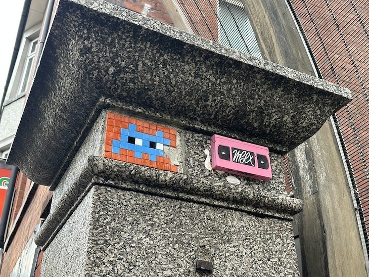 Invader on Wardour Street with pink tape