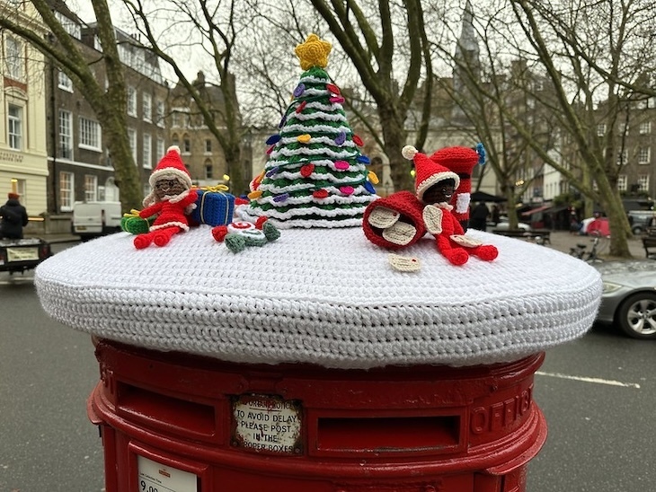 A knitted or crocheted postbox topper in queen square london