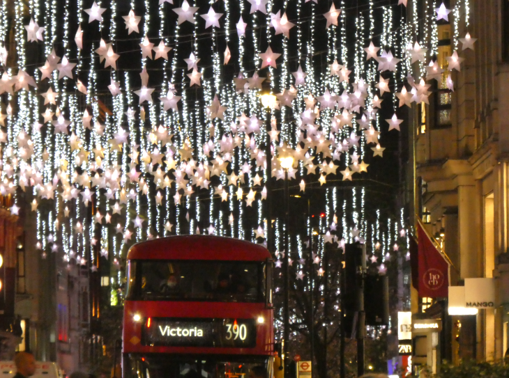 Self-guided Christmas lights walk London 2025: a bus driving beneath star lights on Oxford Street