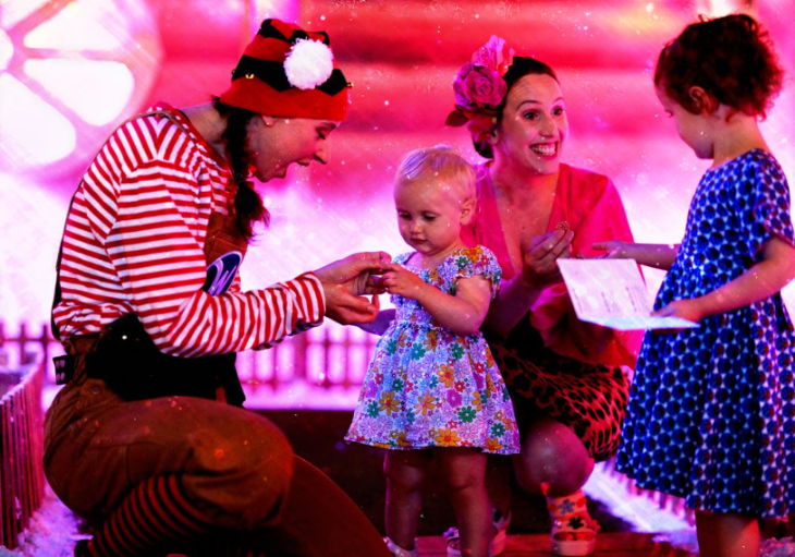 Things to do with kids in London at Christmas 2025: a woman dressed as an elf interacting with a young toddler