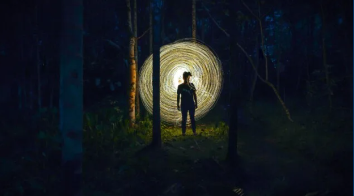 Things to do in London this weekend: a figure illuminated in dark woodland