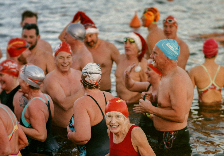 Things to do in London on Christmas Day 2025: swimmers, some wearing Santa hats, in the Serpentine 
