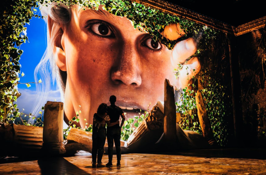 Weekend events in London: two people silhouetted against a large-scale projection showing events in Pompeii
