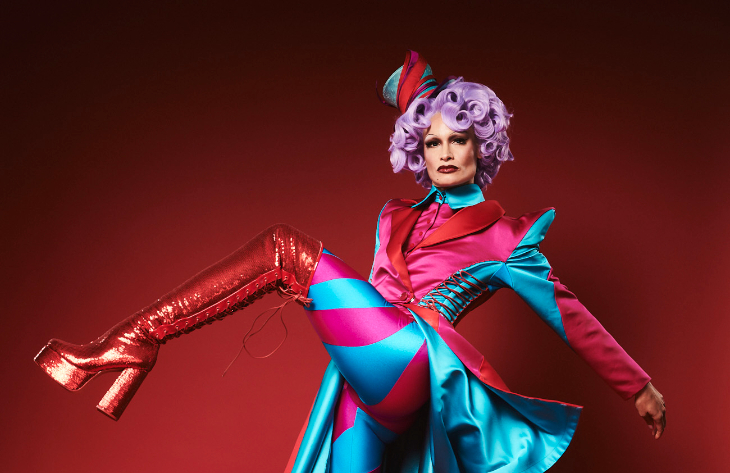 Things to do in London today: a performer in a jazzy costume of red glittery boots, and pink and blue lycra