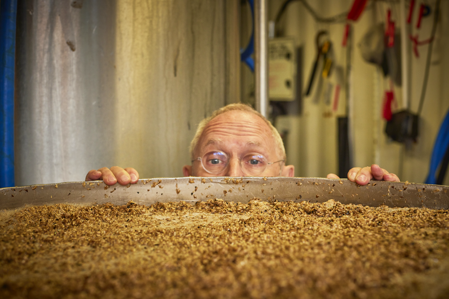 A man peering over a mash tun