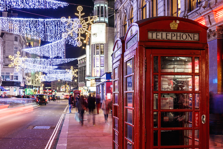Christmas 2025 in London guide: Christmas lights over a London street, with an iconic red phone box in the foreground