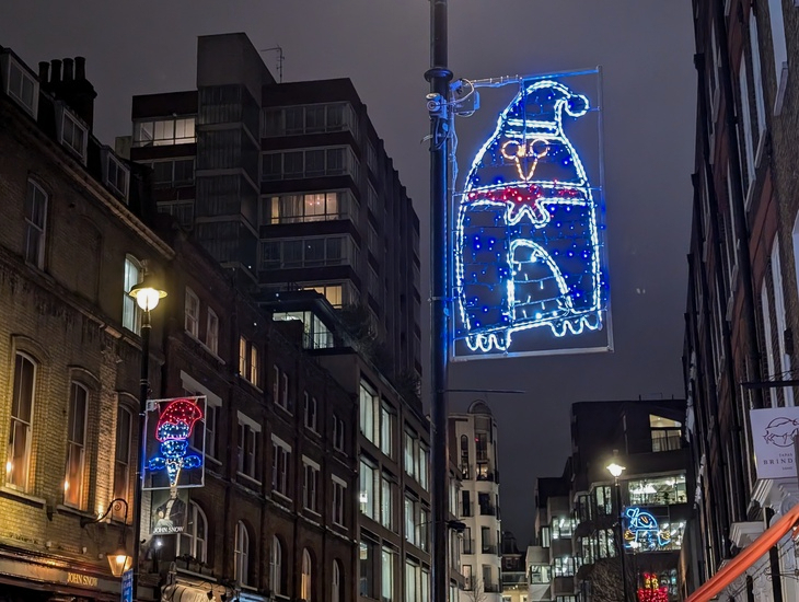 Self-guided Christmas lights walk London 2025: a penguin Christmas light, designed by a child, on a lamppost in Soho