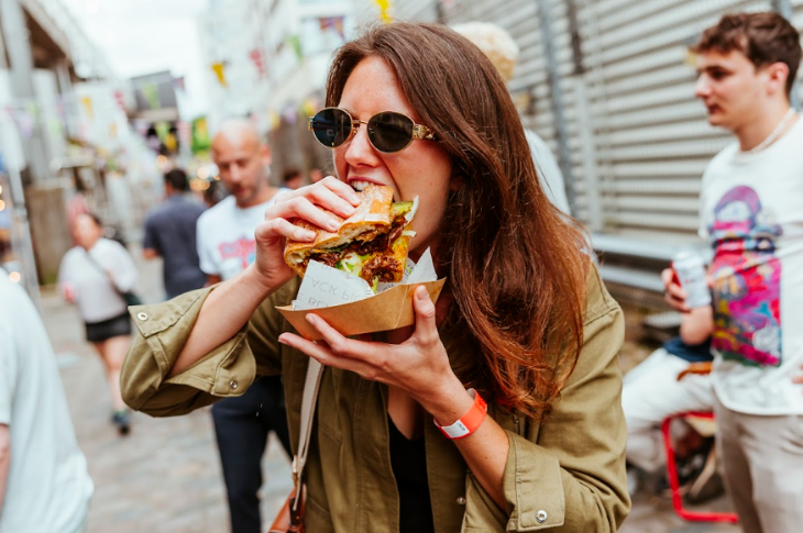 Things to do in London this weekend: a woman taking a bite of a sandwich