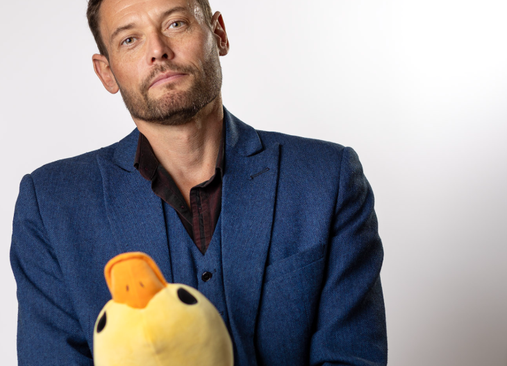 Weekend events in London: a man in a blue suit holding a yellow stuffed toy duck