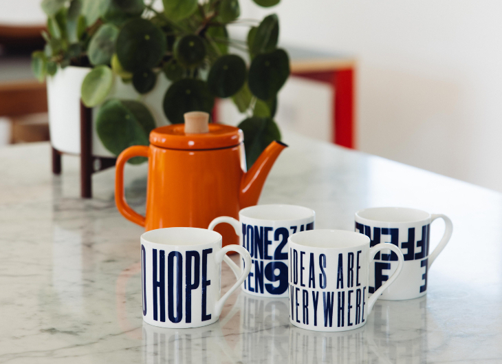 Things to do in London this weeked: a pot plany, a teapot and a set of four mugs on a table