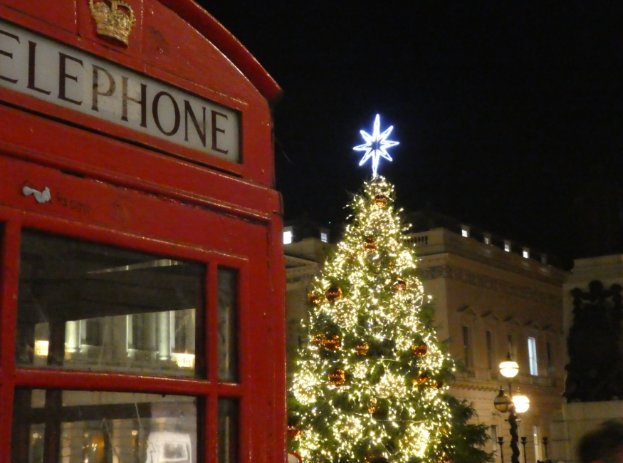 Things to do in London Christmas Eve 2025: a glowing Christmas tree next to a red phone box