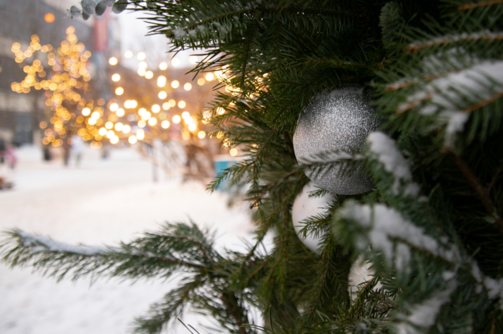 PYO Christmas tree farms London 2025: a silver bauble on a Christmas tree, with Christmas lights in the background