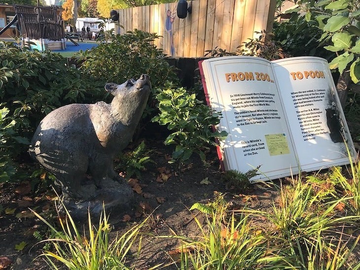 A statue of a small bear who inspired Winnie the Pooh