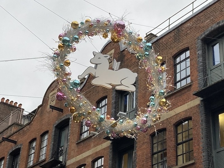 A wounded deer surrounded by a Christmas wreath