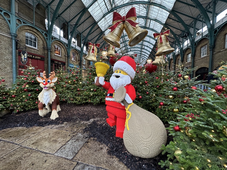 A lego Santa and reindeer in a forest of trees