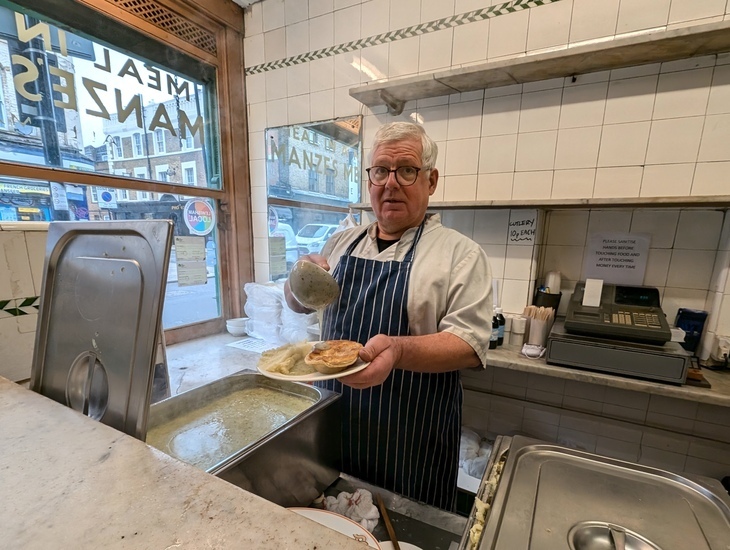 A man serves up pie and mash