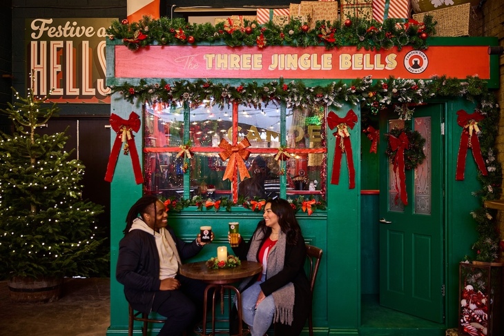 Two people drinking outside a tiny pub