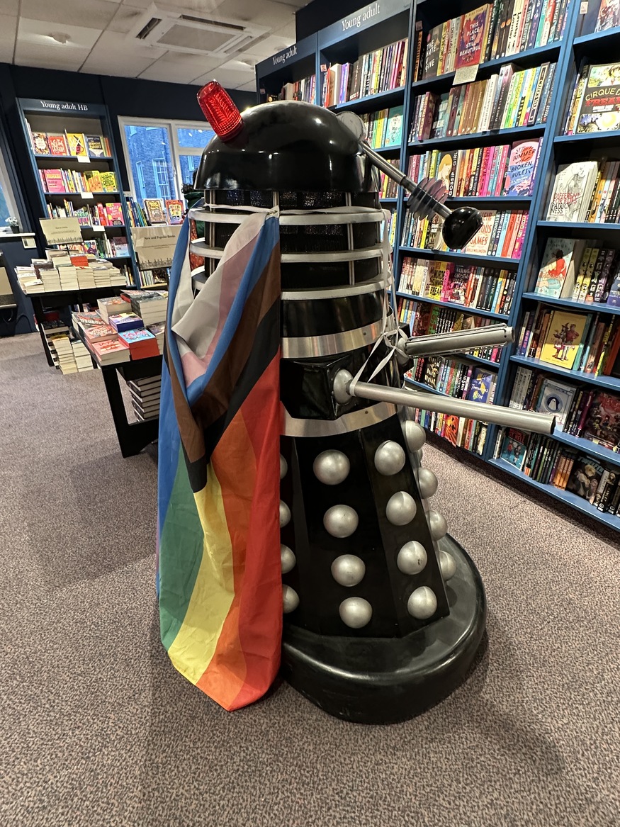 A Dalek draped in a Pride flag
