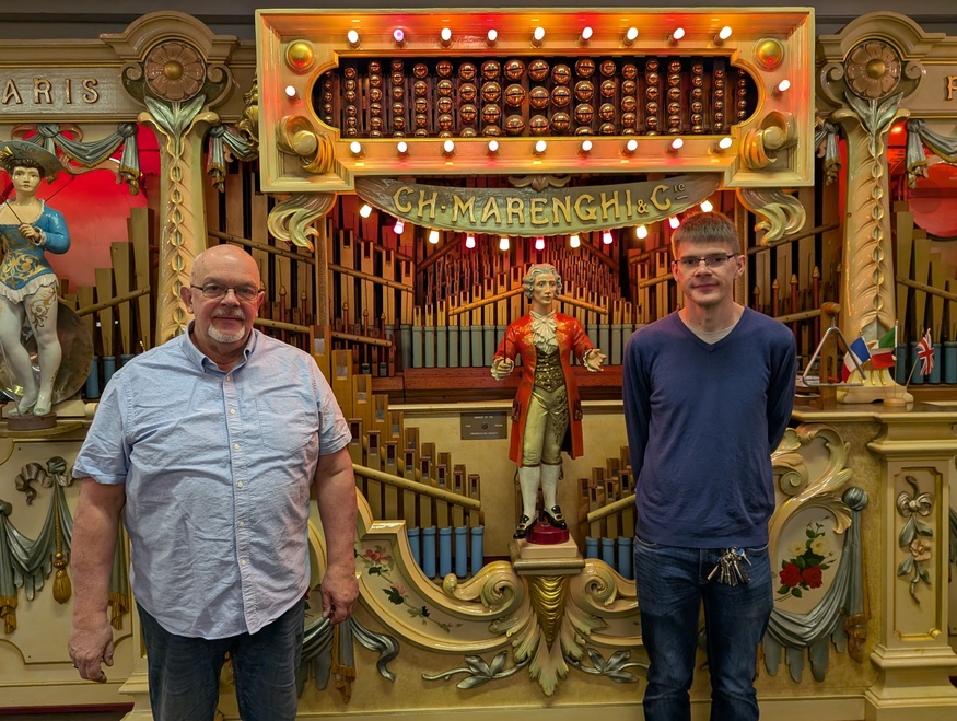 Two men in front of a fair organ