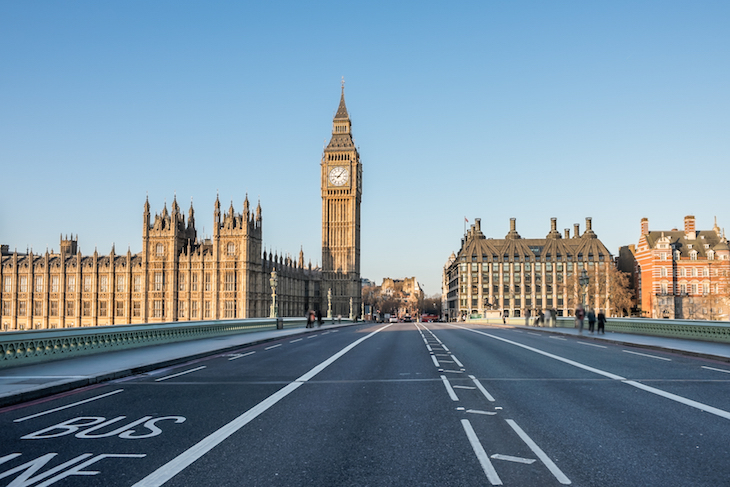 Is much open in London on Christmas Day: Westminster Bridge looking towards the Houses of Parliament, with just a couple of pedestrians and no vehicles.