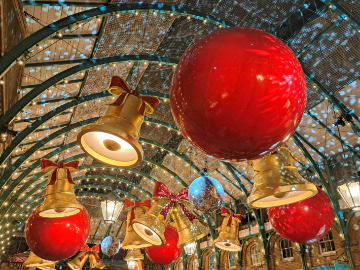 London Christmas lights 2025:  red baubles and gold bells in the Covent Garden Market Hall