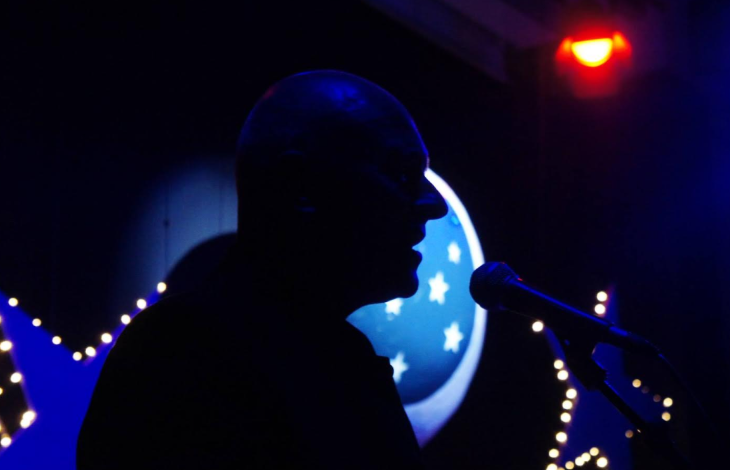 Things to do today in London: a performer and a microphone silhouetted against a backlight on stage