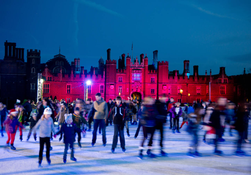 People ice skating in front of Hampton Court Palace
