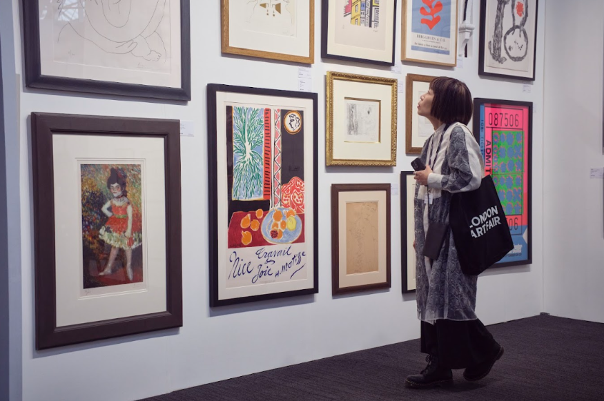 What's on in London in January 2026: a woman looking at artworks mounted on a wall