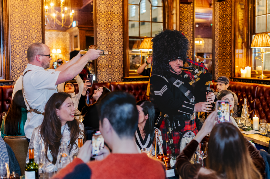 Where to celebrate Burns Night 2026 in London: a bagpiper escorting the haggis through a restaurant